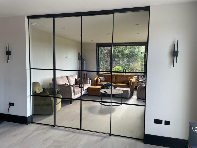 A modern living space featuring sleek black-framed internal french doors that divide rooms while maintaining an open feel.