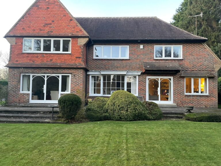 Traditional brick house with heritage windows and a well-maintained garden.